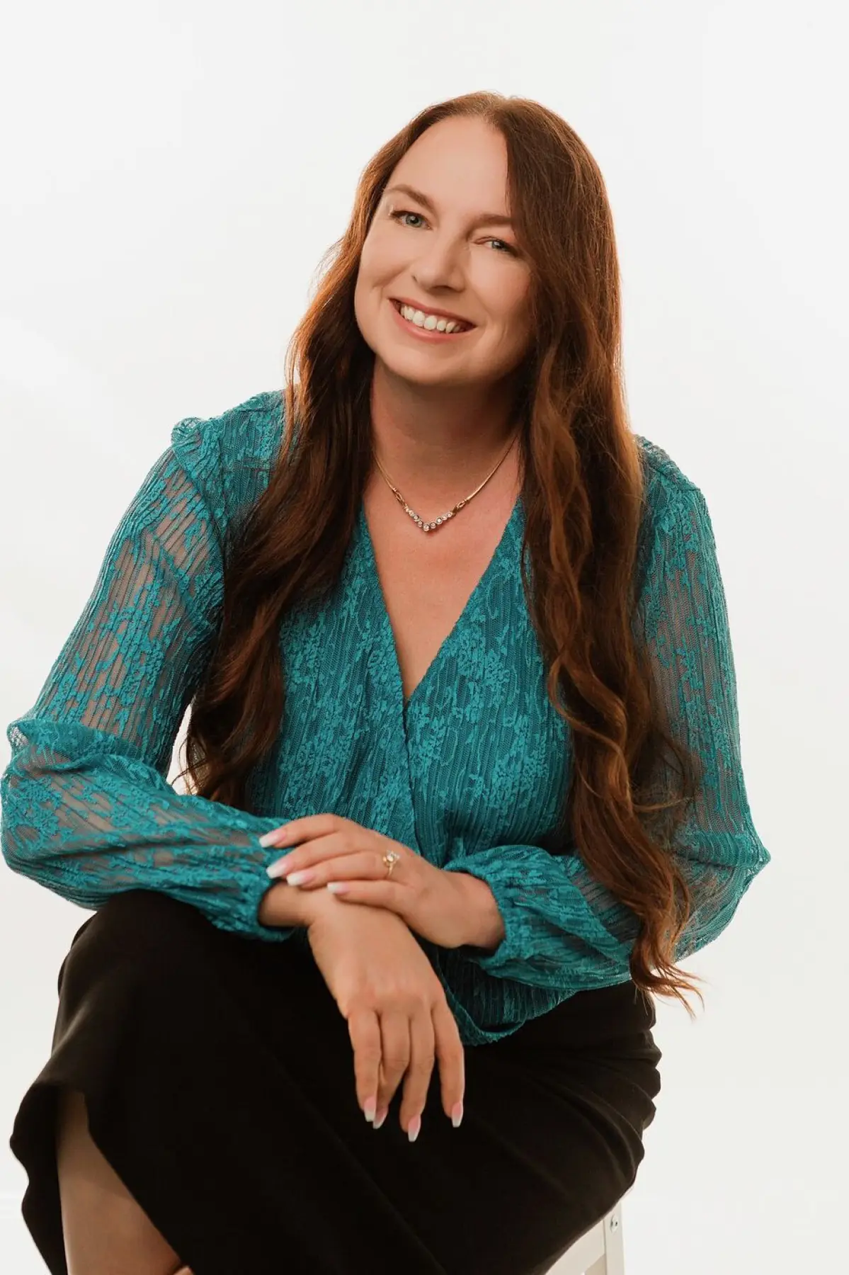 Larissa Mayfield, seated, in a teal blouse